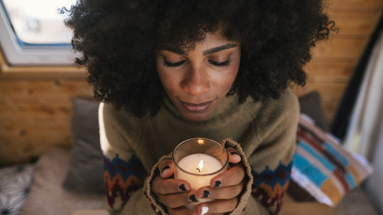 A woman holding a lit candle