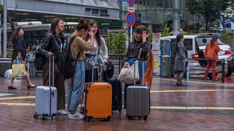 Japanese girls with suitcases in Shibuya's Hachiko Square