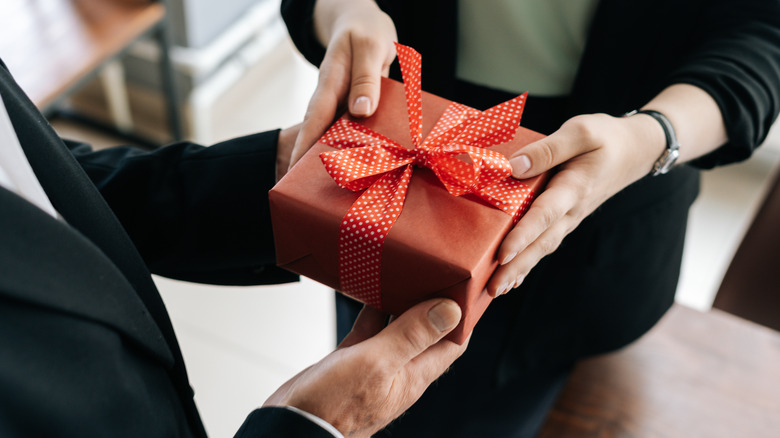 hands of woman giving present