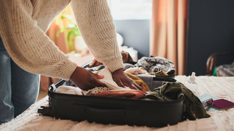 Woman packs suitcase