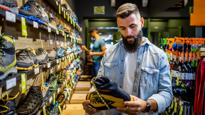 A customer examines footwear in an outfitter store.