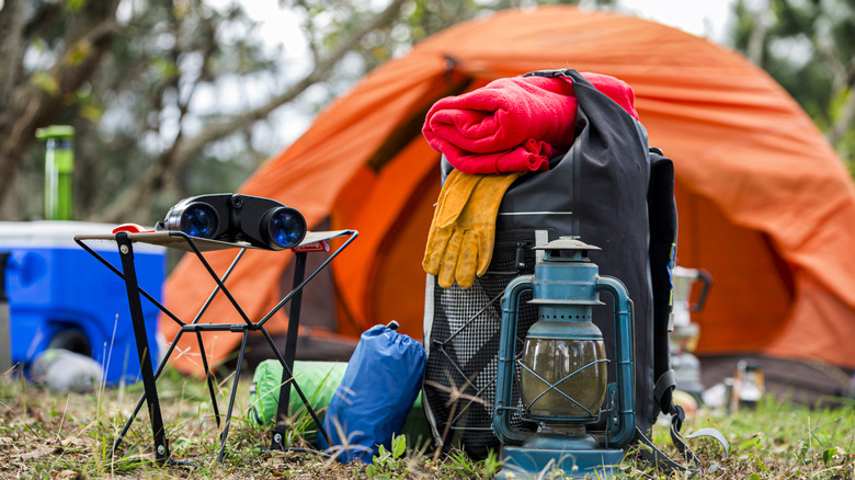 A stack of camping and hiking equipment outdoors.