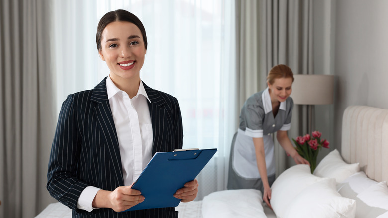 hotel maid arranging the hotel room with her manager