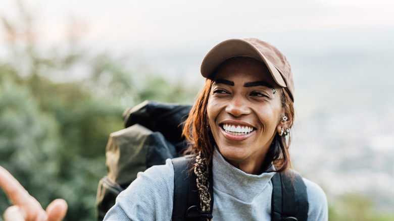 Backpacker smiling in baseball cap