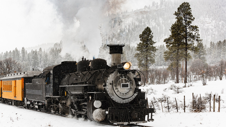 Steam train through mountain snow