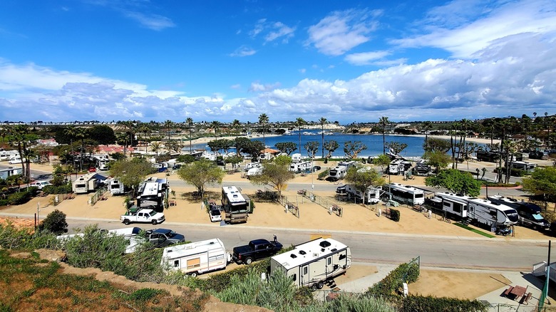 An aerial view of Newport Dunes Waterfront Resort & Marina with RVs, desert scenery, and a lake.