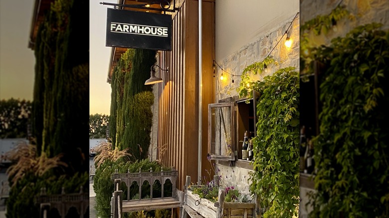 Greenery, benches, and a sign outside of Farmhouse restaurant in Newport Beach, California.