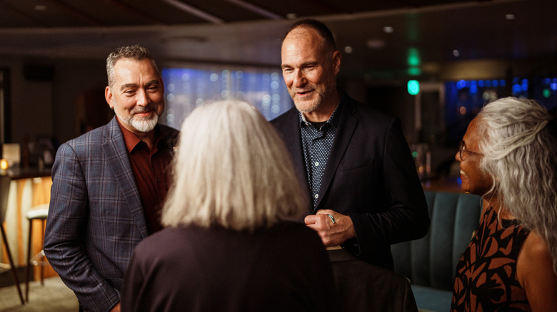 Two men saying goodbye to two women.