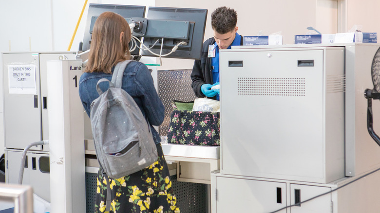TSA officer checking a woman's bag