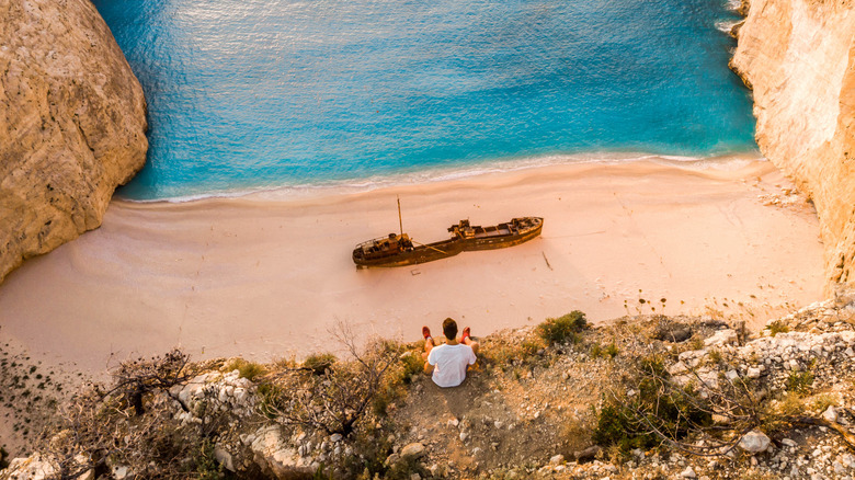 man on cliff overlooking  Shipwreck Beach