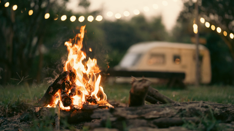 a campfire with RV in the background
