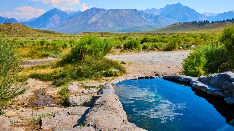 hot spring with mountains in background