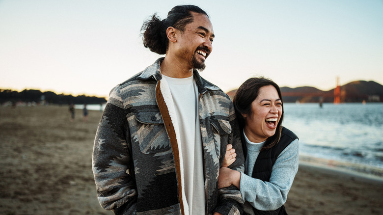 Couple smiling on a winter beach walk