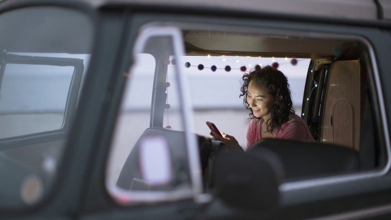 woman in an RV looking at mobile phone