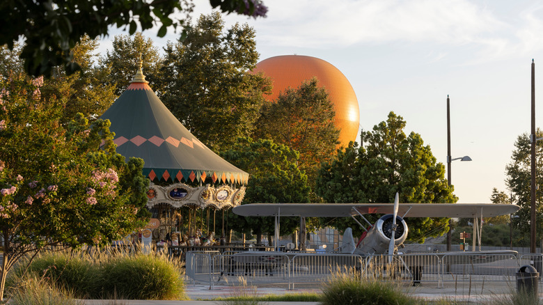 Carousel, giant balloon, and historic warplane lit by early morning light at Orange County Great Park