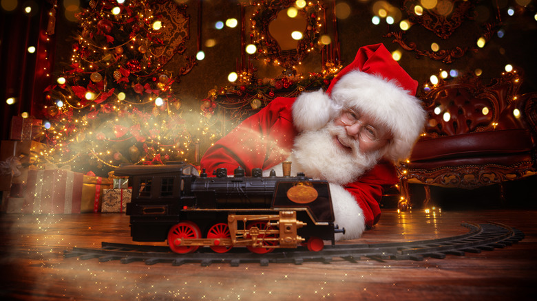 Santa smiling & playing with model steam train