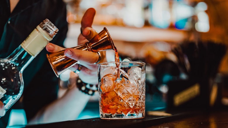 Hand pouring a cocktail