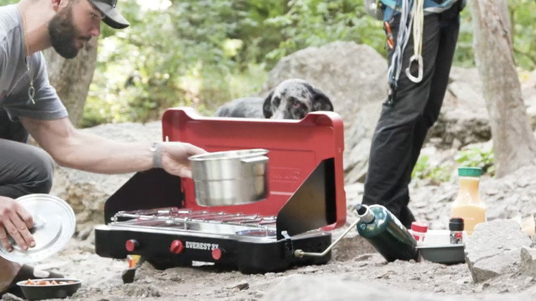 Person cooking with the Camp Chef Everest 2X in the woods