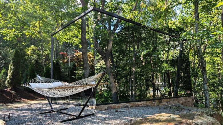 A hammock outside a cabin with mirrored walls in the forest at Bolt Farms