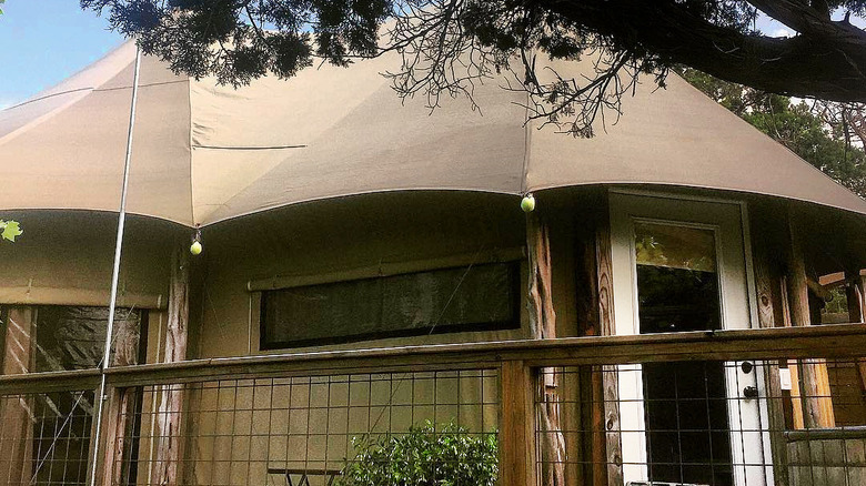 A canvas glamping tent on a deck