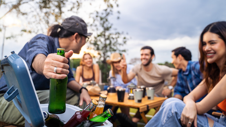 Adults socializing over drinks outside.