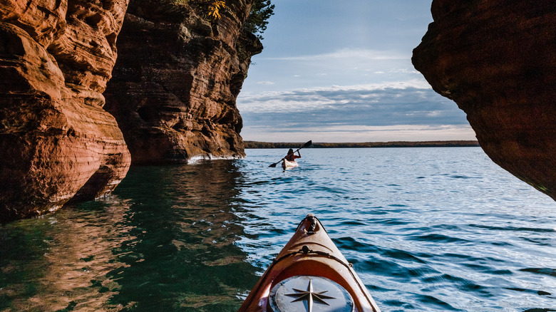 A tent between some trees with a beach and Lake Superior behind it