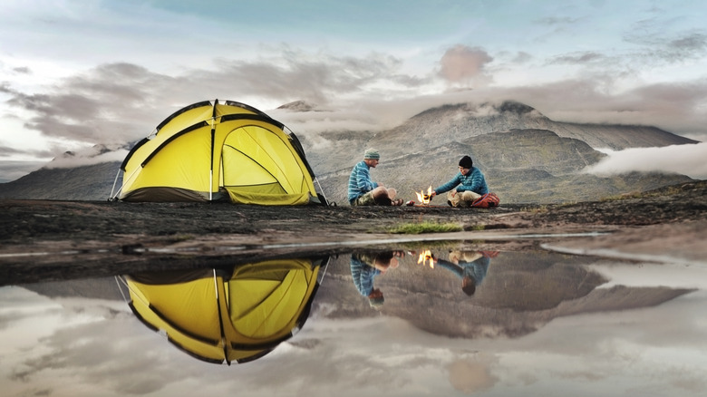 Campers make a fire near their tent in Greenland