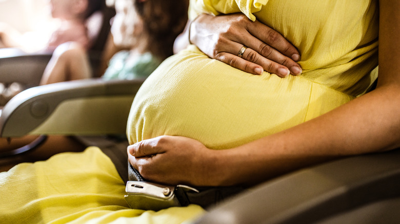 Pregnant person cradling tummy