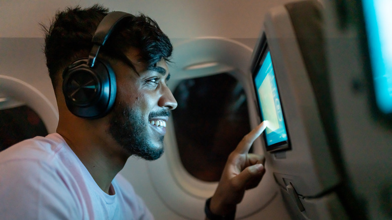 man using in-flight entertainment