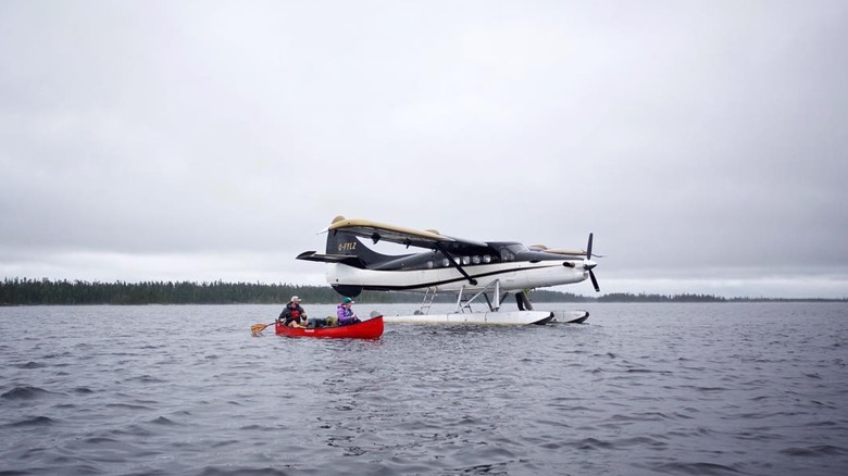 Two people canoeing next to a sea plane in Wabakimi Provincial Park