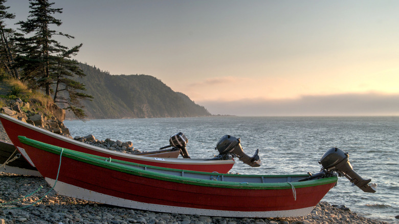 Red boats on the shore of rocky Whistle Beach overlooking the Bay of Fundy, Grand Manan Island, New Brunswick, Canada