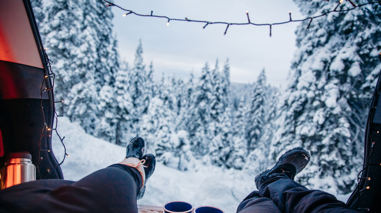 A couple resting in a car looking out at a snowy scene