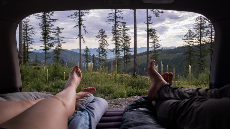 A couple enjoying camp views from their car.