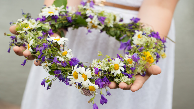 girl holding out flower wreath