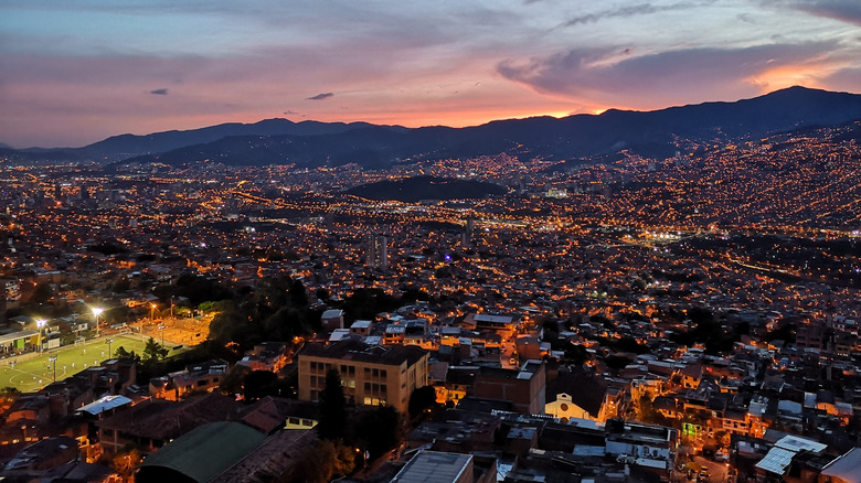 A wide view of the city of Medellin, Columbia in the valley of the mountains during a colorful sunset