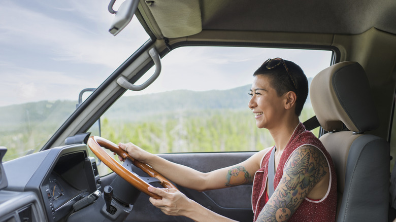 A happy alternative woman drives through the Chinese countryside