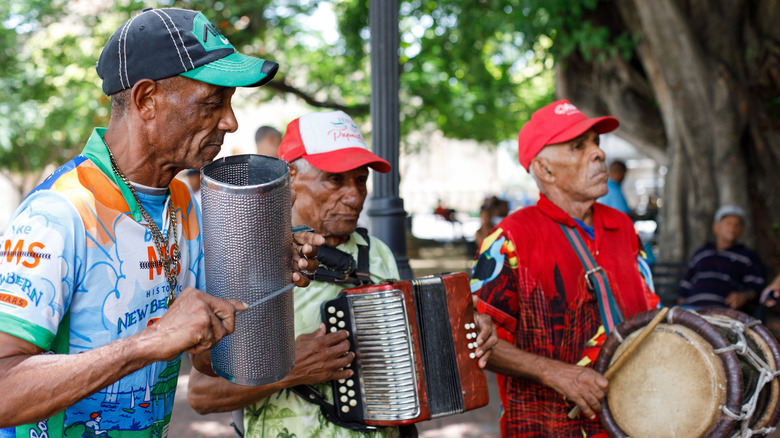 Street musicians playing the accordion and guitar and the Dominican drum