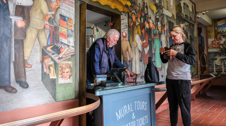 a tourist buying a ticket to use the elevator in Coit Tower San Francisco