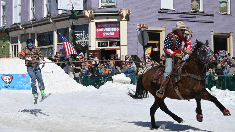 A horse and rider pulls along a skier in Leadville, Colorado.