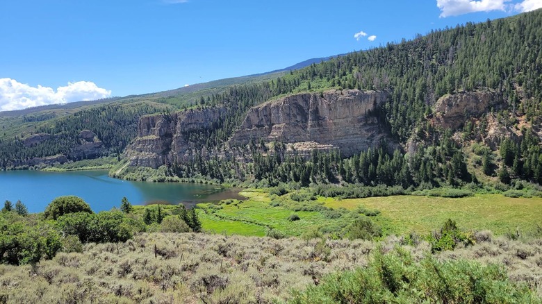 Rocky bluffs leading down tow a marsh and lake in Sweetwater Lake, Colorado
