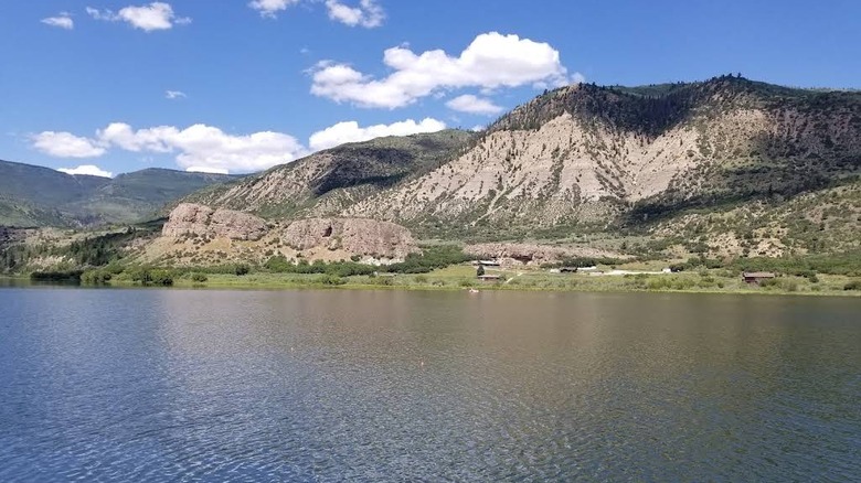 Bluffs and tree-dotted hills rise above the water at Sweetwater Lakein Colorado