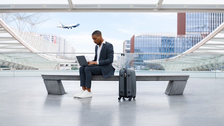 Businessman on laptop in airport