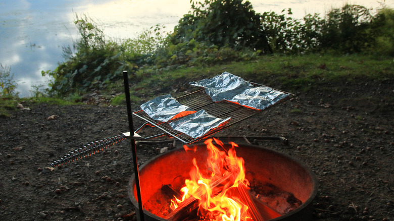 Foil pockets on a grill by the water.