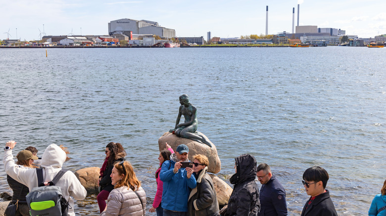 Tourists taking photos in front of Copenhagen's Little Mermaid statue