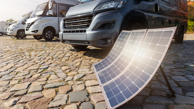 row of caravans with solar panel in sun in foreground