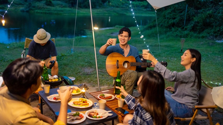 A group of friends around a dinner table camping