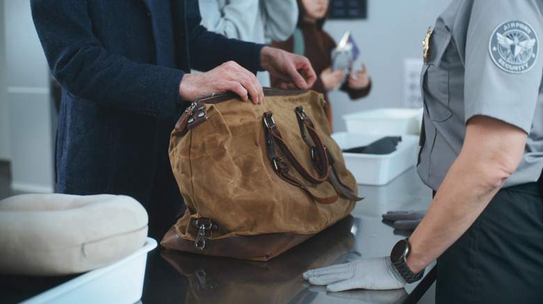 tsa agent about to check a passengers bag
