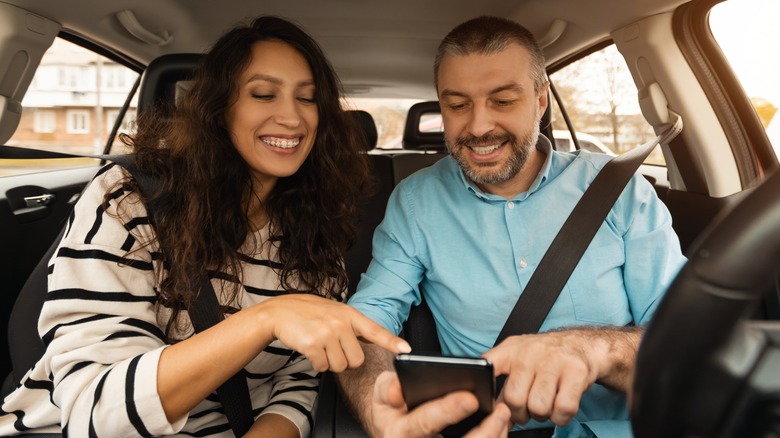 couple on a road trip with phone