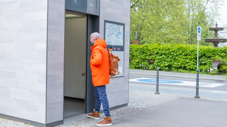 Man walking into public restroom in Europe