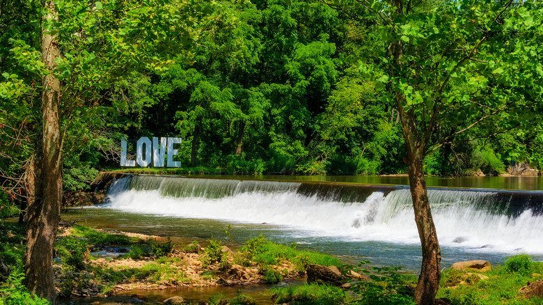 a sign spelling out LOVE by a waterfall